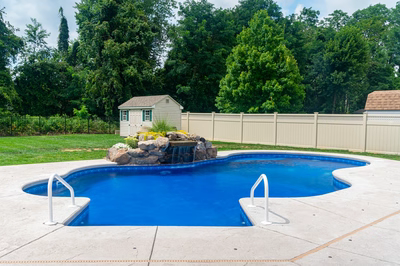 Okere D - Freehold, NJ - A backyard with a swimming pool and a small waterfall.