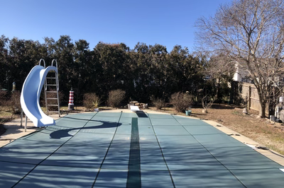 Oneonta C - Hamilton Square, NJ - A playground with a blue slide in the middle of a backyard surrounded by trees