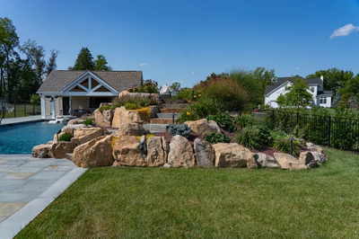 Otaki G - Ivyland, PA - A large rock garden next to a swimming pool in a backyard.
