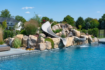 Otaki K - Ivyland, PA - A swimming pool with a water feature and a water slide in a backyard setting