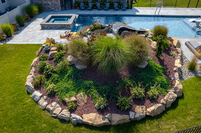 Otaki N - Ivyland, PA - A backyard with a swimming pool surrounded by lush greenery and rocks