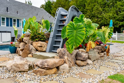 Otodome E - Tinton Falls, NJ - A rock garden with a slide in the middle of it, surrounded by plants and flowers
