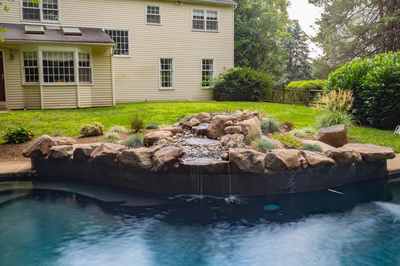 Owen D - Bryn Mawr, PA - A backyard with a swimming pool and a waterfall feature