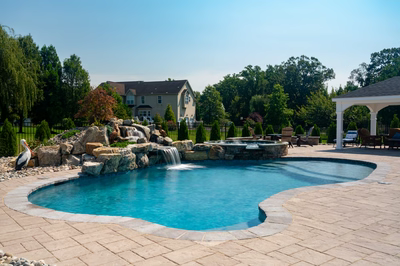Owharoa E - Swedesboro, NJ - A large backyard with a swimming pool and a waterfall.