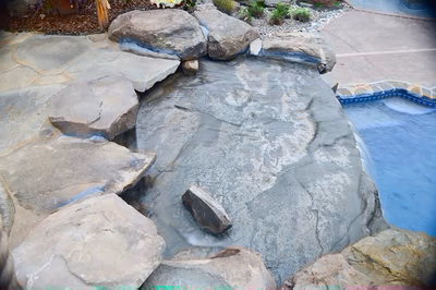 Paluth-K - Two men working on a concrete pool in a backyard.