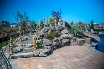 Pearl C - Lincroft, NJ - A backyard with a stone play area and a water feature