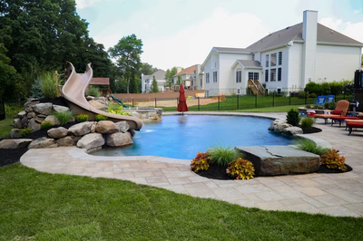 Pongour C - Mt. Laurel, NJ - A backyard with a swimming pool and a water feature with a slide