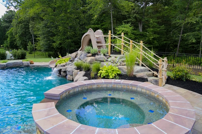 Pongour E - Mt. Laurel, NJ - A swimming pool with a water feature and a slide in a backyard setting
