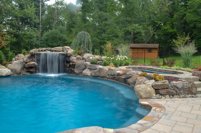 Prenn H - Limerick, PA - A swimming pool with a waterfall in the middle surrounded by lush greenery
