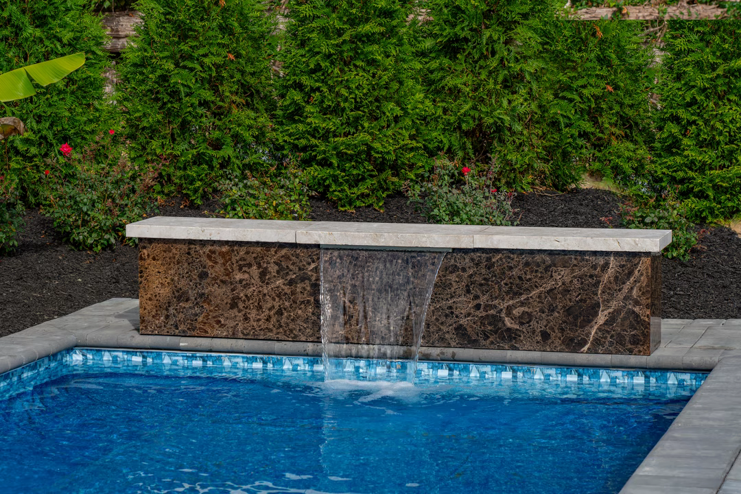 Formal B - Forrest Hills, MD - A rectangular pool with a waterfall in the middle surrounded by lush greenery