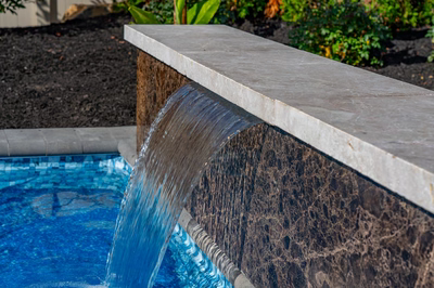 Formal B - Forrest Hills, MD - A water feature in a swimming pool surrounded by greenery