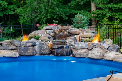 Ramona B - Bloomsbury, NJ - A swimming pool with a waterfall and fire features surrounded by lush greenery