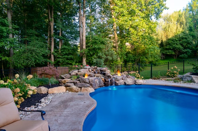 Ramona C - Bloomsbury, NJ - A backyard with a swimming pool surrounded by lush greenery and a fire pit