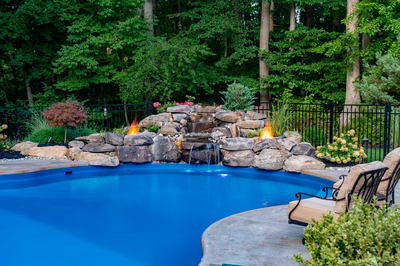 Ramona E - Bloomsbury, NJ - A swimming pool surrounded by lush greenery and a fire pit.