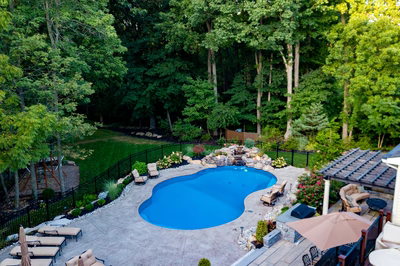 Ramona I - Bloomsbury, NJ - A backyard with a swimming pool surrounded by lush greenery and trees