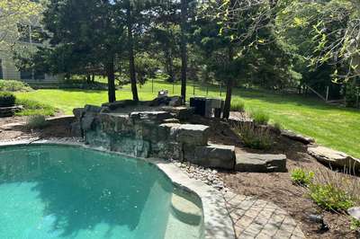Ripon E - Red Bank, NJ - A backyard with a swimming pool and a waterfall.
