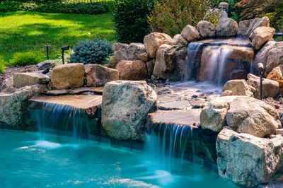 Ripon J - Red Bank, NJ - A small waterfall cascades over rocks into a turquoise pool surrounded by lush greenery