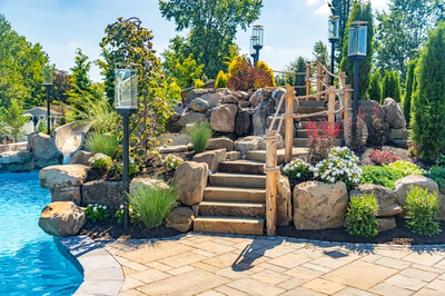 Russell F - Maple Shade, NJ - A landscaped backyard with a rock waterfall and steps leading to a swimming pool