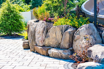 Russell I - Maple Shade, NJ - A large rock retaining wall with plants and flowers in a garden setting