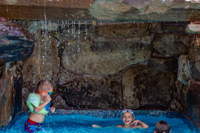 Russell K - Maple Shade, NJ - A group of children playing in a swimming pool with a waterfall in the background