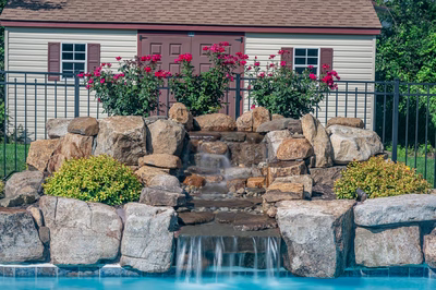 Ryuzu C - Collegeville, PA - A small house with a brown door and brown shutters next to a pool with a waterfall feature