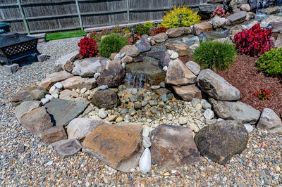 Sendo E - Sewell, NJ - A rock garden with a small waterfall in the middle surrounded by colorful flowers