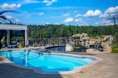 Shebelle - Hammonton, NJ - A beautiful outdoor swimming pool with a waterfall and a gazebo surrounded by lush greenery