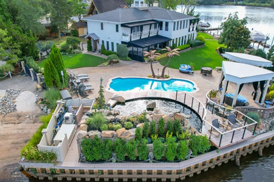 Shebelle - Hammonton, NJ - A large white house with a pool and a gazebo on a dock surrounded by lush greenery