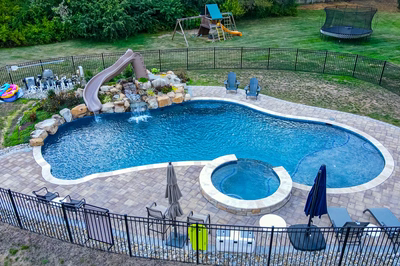 Shomyo I - Princeton Junction, NJ - A backyard with a swimming pool, a water feature, and a play area