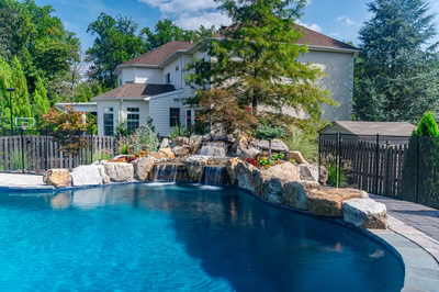 Sipi C - Pikesville, MD - A large white house with a waterfall in the middle of a swimming pool surrounded by lush greenery