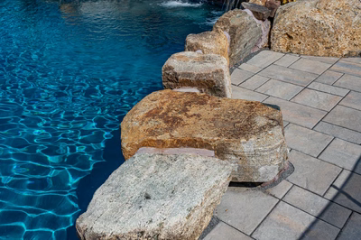 Sipi G - Pikesville, MD - A swimming pool with clear blue water and rocks along the edge
