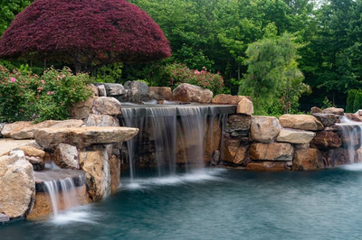 Sisiyi N - Manalapan, NJ - A beautiful garden with a waterfall surrounded by lush greenery and colorful flowers
