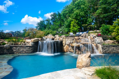 Spirit A - Cream Ridge, NJ - A beautiful outdoor swimming pool with a waterfall feature surrounded by lush greenery