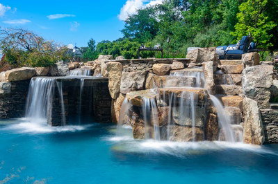 Spirit B - Cream Ridge, NJ - A beautiful outdoor swimming pool with a waterfall feature surrounded by lush greenery