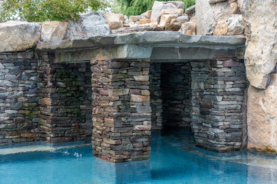 Spirit C - Cream Ridge, NJ - A stone structure with a pool in the middle of it, surrounded by rocks and greenery