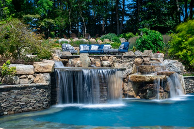 Spirit D - Cream Ridge, NJ - A beautiful outdoor swimming pool with a waterfall and seating area surrounded by lush greenery