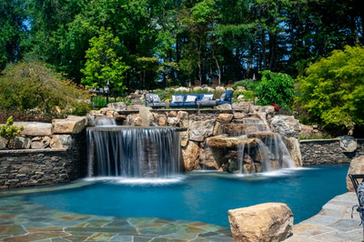 Spirit E - Cream Ridge, NJ - A swimming pool with a waterfall in the middle surrounded by lush greenery