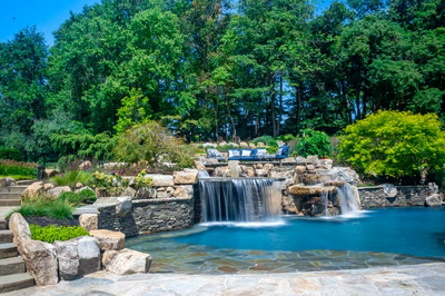Spirit G - Cream Ridge, NJ - A beautiful outdoor swimming pool with a waterfall surrounded by lush greenery