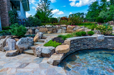 Spirit H - Cream Ridge, NJ - A stone retaining wall around a swimming pool with steps leading up to it