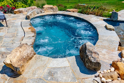 Spirit M - Cream Ridge, NJ - A hot tub surrounded by rocks and pebbles in a backyard setting