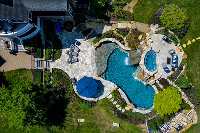 Spirit T - Cream Ridge, NJ - A bird's eye view of a backyard with a swimming pool surrounded by lush greenery and a waterfall