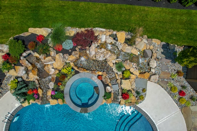 Spray N - Franklinville, NJ - A bird's eye view of a backyard with a swimming pool surrounded by rocks and plants