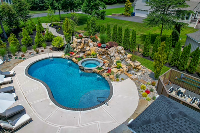 Spray O - Franklinville, NJ - A large backyard with a swimming pool surrounded by lush greenery and a waterfall