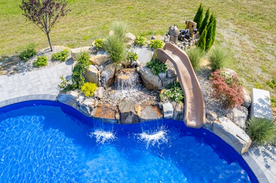 Tamolitch E - Millstone, NJ - A swimming pool with a water feature and a slide in a backyard setting