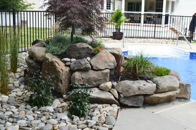 Tana D - Bayville, NJ - A rock garden next to a swimming pool in a backyard.