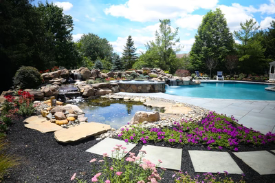 Tanner C - West Windsor, NJ - A beautiful backyard with a swimming pool surrounded by lush greenery and colorful flowers
