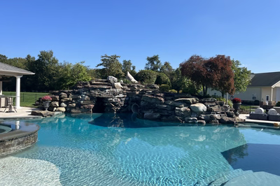 Tchupala A - Medford, NJ - A large swimming pool with a stone waterfall in the middle of it