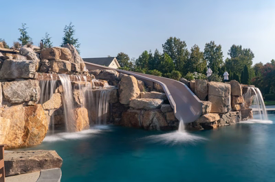 Tchupala E - Medford, NJ - A large rock pool with a water feature and a slide
