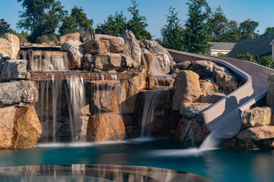 Tchupala I - Medford, NJ - A large rock waterfall with a slide in the middle of a pool
