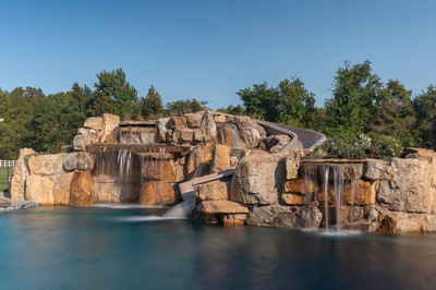 Tchupala M - Medford, NJ - A large rock pool with a waterfall and a winding path in the background